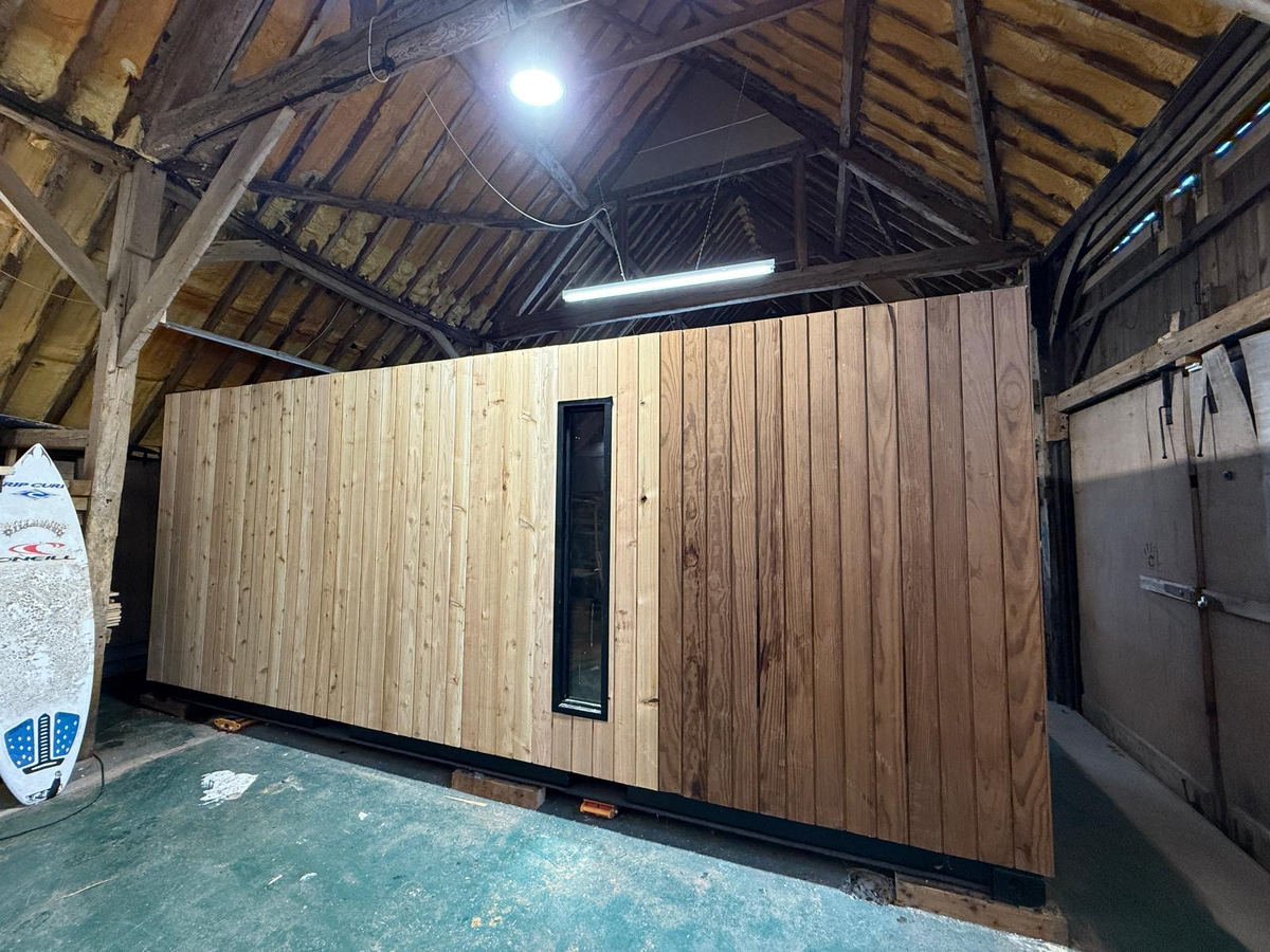 Corva exterior — natural cedar cladding with slim glazed opening