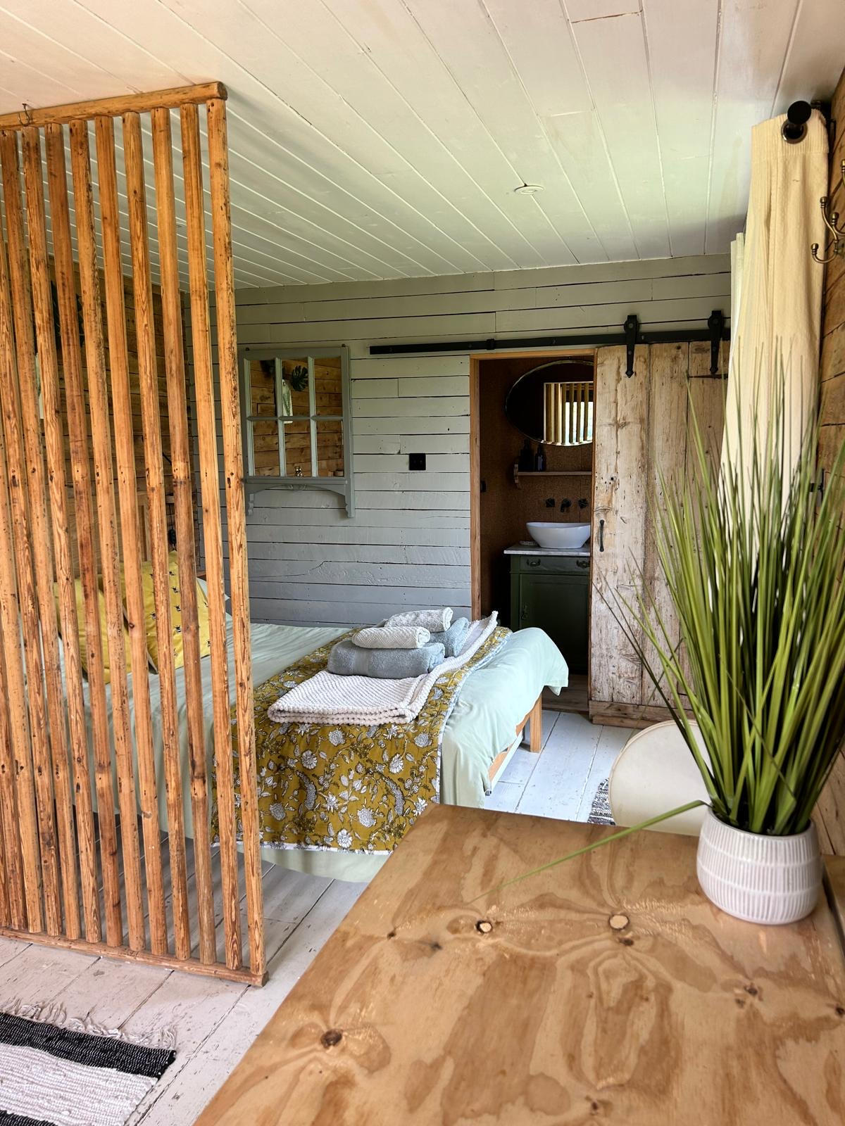 Kalou cabin bedroom with plant, handbuilt cabinetry, West Sussex