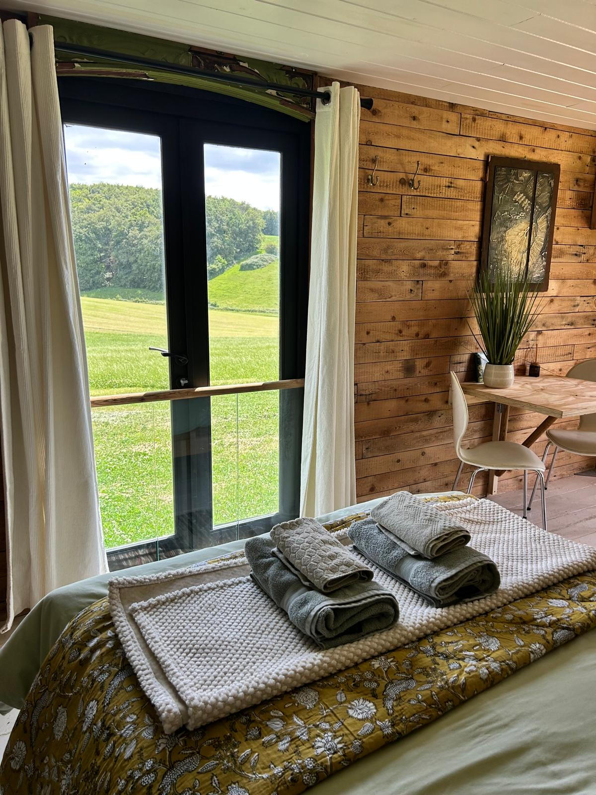 Kalou cabin bedroom, wide view with dining nook and countryside beyond